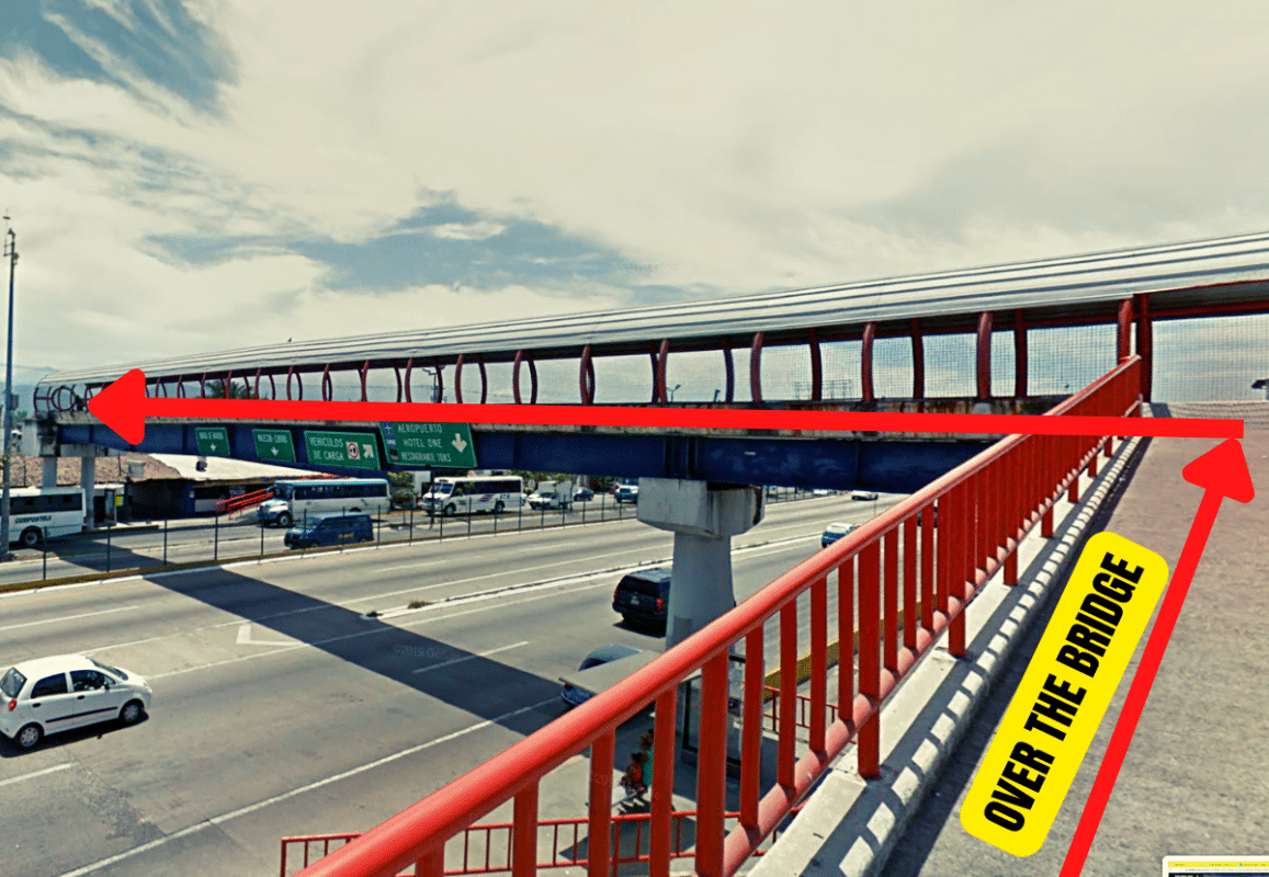 Walk over the main roadway via the bridge to get to the Uber pickup zone.