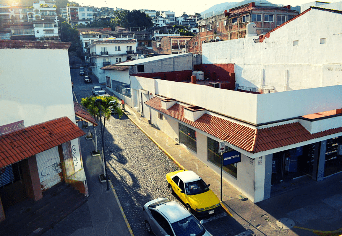 An Uber car and taxi next to each other on the street of PV.